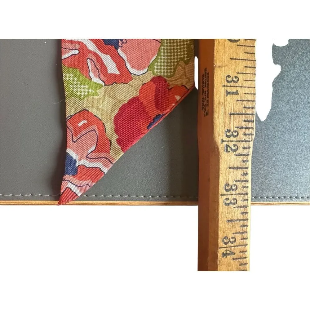 COACH silk twilly scarf orange poppy and tan signature Cs background